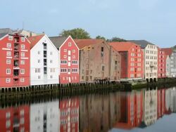 Trondheim Norway cruise Hurtigruten the famous old warehouses now homes over river with reflections on water Stock Footage