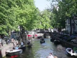 WS People sitting at outdoor cafe while cars parked on side street / Amsterdam, The Netherlands, Holland Stock Footage
