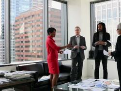 WS four coworkers in corner office in discussion over documents Stock Footage