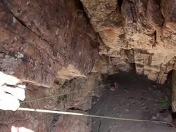 Handheld tilt of a rock-climber at the bottom of a cliff. Stock Footage