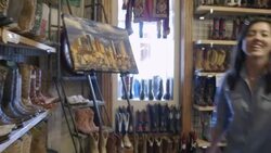 Excited group of friends walk through Western store looking at cowboy boots Stock Footage