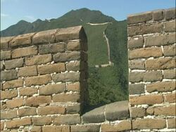 Great Wall of China snaking up hill, shot through battlements, Mutianyu, China Stock Footage