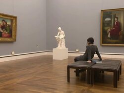 Alte Pinakothek, indoor, art, people, paintings and sculpture, woman sitting on chair and looks at paintings Stock Footage