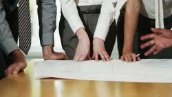 Business people discussing blueprints in conference room Stock Footage