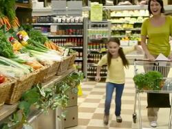 Mother and children in fruit and vegetable section of supermarket Stock Footage