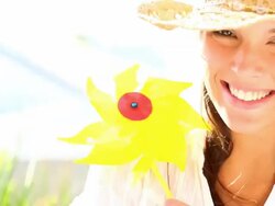 Cute female wearing a sun hat and playing with pinwheel Stock Footage