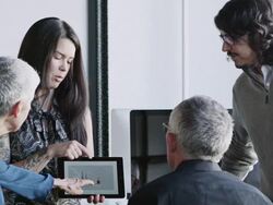 MS PAN R/F businesswoman presenting project on digital tablet to coworkers in high tech startup office Stock Footage