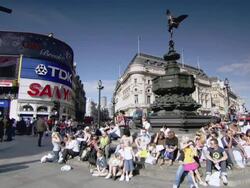 PAN Tourists by fountain with the statue of the Angel of Christian Charity in Piccadilly Circus / London, England, United Kingdom Stock Footage