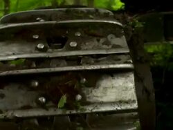 Hand held close up, following the wheels of the feller buncher from behind, as it moves forward. Stock Footage