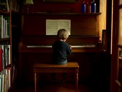 Slow push in on boy playing piano. Stock Footage