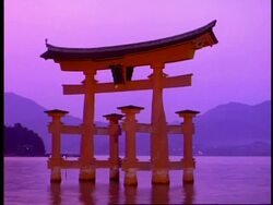 T/L MCU of floating gate of the Itsukushishima shrine, at dusk, amazing pink/purple colours reflected in water and sky, Miya-Jima island, Japan Stock Footage