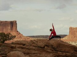 Wide shot of woman doing yoga on mountain / Moab, Utah, United States Stock Footage