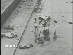 1947: INDO-PAKISTANI CONFLICT: ** VS Burning buildings along streets of India, Indians carrying dead body, SEMI-GRAPHIC various dead bodies, including boy, on street, one wrapped. WS Cow walking war torn streets. India, Pakistan, Muslim, Hindu Instructional Video