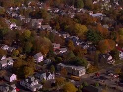 Aerial point of view over houses and streets in suburban town in Autumn / Maine Stock Footage