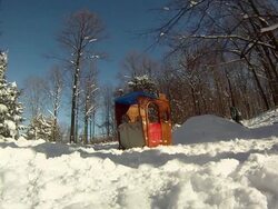 A young man snowboarding through trees and jumping over a playhouse. - Slow Motion - Model Released - HD Stock Footage