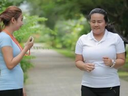 Personal trainer timing a female runner Stock Footage