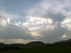 WS View of Silhouetted mountain range with large cloud bank moving across and covering rising sun / Namaqualand, Northern Cape, South Africa Stock Footage