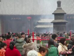 MS Pilgrims touching stone tortoise pray for good luck during Chinese Lunar New Year at Taoist temple / xi'an, shaanxi, china Stock Footage