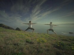 MS POV TS SLO MO Couple practicing yoga overlooking Pacific Ocean / Port Orford, Oregon, United States Stock Footage