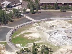 WS AERIAL View of tourist watching hot water fountain at Emerald Pool / Wyoming, United States Stock Footage