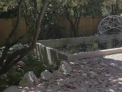 Patterns of dappled light move across rocks in garden. Stock Footage