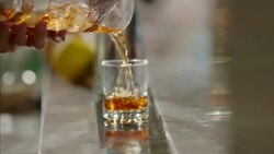 Bartender pours mixed cocktail drink into glass Stock Footage