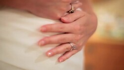 HANDHELD CLOSE UP bride's hands on stomach in wedding dress Stock Footage