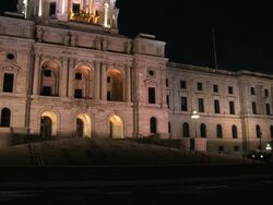 A horse-drawn carriage walks by, silhouetted by the glow of the Minnesota State Capitol building Stock Footage