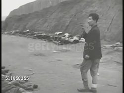 1950: KOREAN CONFLICT (WAR): GRAPHIC South Korean male counting row of bodies, dead people, unidentified soldiers or civilians, lying side-by-side on roadside. MS Bombed structure. HA PAN People walking in bombed town, ruins, few buildings standing. Instructional Video