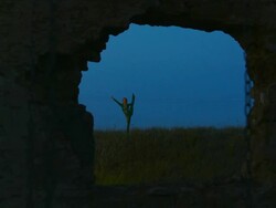 Acrobat exercising in the field at night Stock Footage