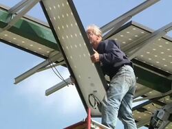 WS ZO Technician begins to attaching panel to photovoltaic array with energy efficient house / Grass Lake, Michigan, USA  Stock Footage