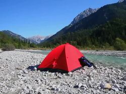 PAN Backpacker Camping on Rissbach River in the Karwendel Mountain Range in the Alps  Stock Footage