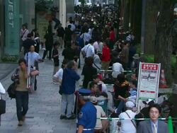MS Shot of people sitting on floor queuing for launch of iPhone / Tokyo, Japan Stock Footage