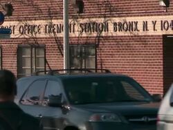 pedestrians and traffic walking in front of the post office near the bus stop near east tremont avenue and arthur avenue in the bronx during the day Stock Footage