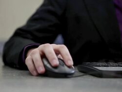 Bank teller using computer keyword and mouse in bank Stock Footage