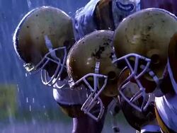 MS PROFILE football players in position at line of scrimmage / they start to block / rain Stock Footage