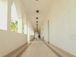 Woman walking through long corridor of an arabian style structure Stock Footage