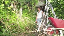 Woman Overwhelmed by Overgrown Garden Stock Footage