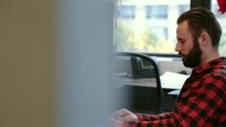 Trendy young businessman types on laptop computer in big corner-office (dolly shot) Stock Footage