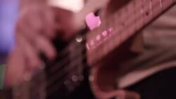 Young musician picks hard and fast on bass guitar Stock Footage