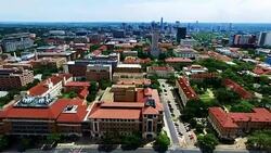 Side Pan Motion Clip Extreme High Contrast shot UT Tower and skyline in the distance Aerial Fly by Austin Texas Over University of Texas Stock Footage