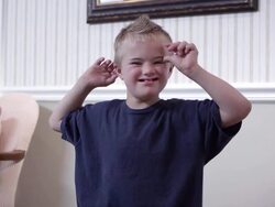 Medium shot of a downs boy clapping Stock Footage