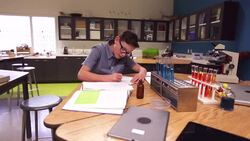 Schoolboy taking notes scientific experiment school laboratory classroom Stock Footage