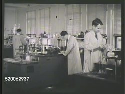 1935: RESEARCH LABORATORY: WS Laboratory building. INT WS Two males, one in business suit, one in lab coat, talking. VS Scientists in antifreeze research lab looking at solutions in tubes, into microscope, at water test instrument, & water tubes. Instructional Video