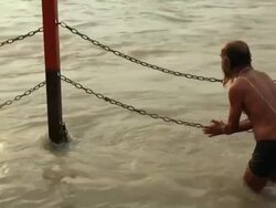 Senior man worshipping at riverbank, Ganges River, Haridwar, Uttarakhand, India Stock Footage