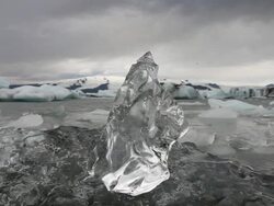 MS Smaller piece of clear glacial ice sitting at top of larger clear glacial ice piece in front of Jokulsarlon glacial lagoon / between Skaftafell National Park and Hofn, Austur-Skaftafellssysla, Iceland  Stock Footage