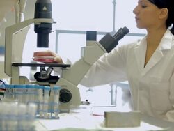 MS TU PAN Female laboratory technician looking into microscope in Cancer research Healthcare medicine Industry DNA sequencing Laboratory / Vancouver, BC, Canada Stock Footage