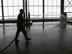 A maintenance crew sprays down loading decks in a paper recycling plant. Stock Footage