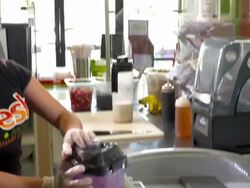 MS juice bar girl removes plastic jar from blender and pours raw pitaya smoothie into plastic serving cup Stock Footage