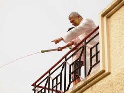 Senior man playing holi festival with his grandson at roof top  Stock Footage